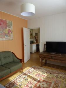uma sala de estar com um sofá, uma mesa e uma televisão em Gîte Les Hauts de Curemonte em Curemonte