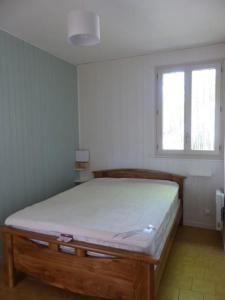 um quarto com uma cama num quarto com uma janela em Gîte Les Hauts de Curemonte em Curemonte