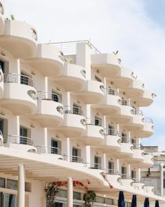 an apartment building with balconies on it at Aegean Blue Beach Hotel in Nea Kalikratia