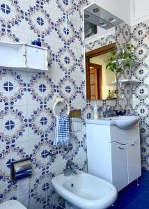 a blue and white bathroom with a sink and a toilet at Guest House A Due Passi in Olbia