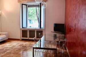 un soggiorno con tavolo in vetro e finestra di Appartamento in centro a Milano