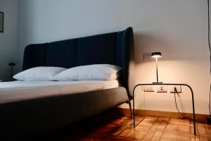 un letto con testata blu e un tavolo con una lampada di Appartamento in centro a Milano