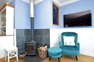 a living room with a blue chair and a stove at Craignethan in Kames