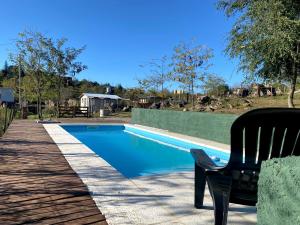 a black chair sitting next to a swimming pool at Villa Nicolasa in Villa Yacanto