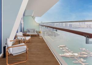 un balcon avec vue sur l'eau et les bateaux dans l'établissement Raffles Doha, à Doha