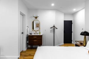 1 dormitorio con cama, lavabo y espejo en King Bed, DTWN Historic Hotel, Fiber Wifi, 50 in Roku TV, Room # 106, en Bangor