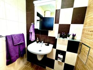 a bathroom with a sink and a mirror and purple towels at Blue Sunrise Comfort in St. St. Constantine and Helena +11 photos
