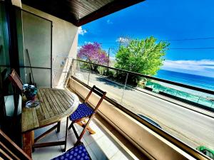 a balcony with a table and chairs and a view of the ocean at Blue Sunrise Comfort in St. St. Constantine and Helena