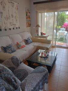 sala de estar con sofá blanco y mesa de cristal en Casa coqueta con jardin, en La Redondela