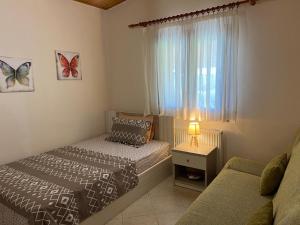 ネア・ポティダイアにあるPotidaia Elegant Summer Houseのベッドルーム1室(ベッド2台付)、蝶が描かれた窓が備わります。