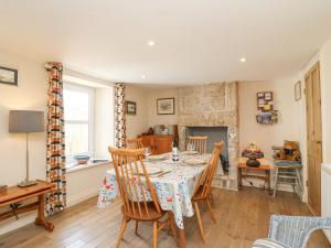 a dining room with a table and chairs and a fireplace at Bowman's Cottage in Portland