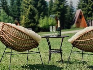 Una botella de vino sentada en una mesa con dos sillas en Bude Mestia cottages en Mestia