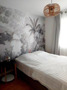 - une chambre avec un lit et une fresque murale dans l'établissement Villa entière avec jardin, à Aix-les-Bains