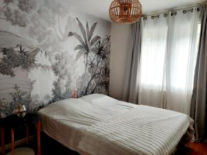 a bedroom with a bed and a floral wall at Villa entière avec jardin in Aix-les-Bains