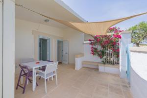 un patio con tavolo, sedie e fiori di Casetta Margherita a Otranto