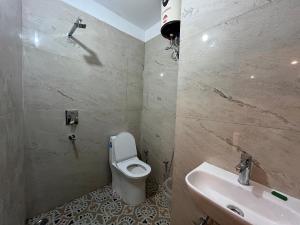 een badkamer met een toilet en een wastafel bij Tatsat Hostel in Rishīkesh