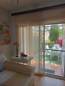 sala de estar con sofá y puerta corredera de cristal en Casa coqueta con jardin, en La Redondela