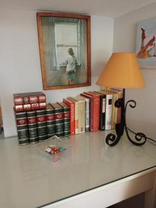 un escritorio con una lámpara y un montón de libros en Casa coqueta con jardin, en La Redondela