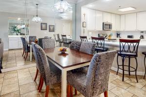 a kitchen and dining room with a table and chairs at Enclave 605 in Orange Beach