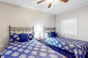 a bedroom with two beds and a ceiling fan at Enclave 605 in Orange Beach +30 photos