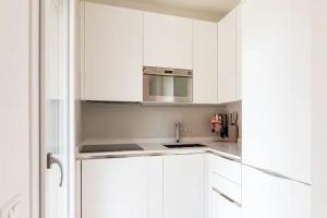 a white kitchen with white cabinets and a sink at Emme Apartment IUN (Q8410) in Cagliari