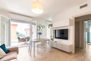 a living room with a dining table and a television at Emme Apartment IUN (Q8410) in Cagliari