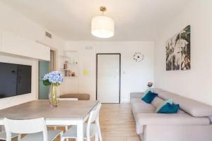 a living room with a table and a couch at Emme Apartment in Cagliari