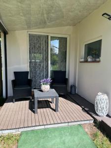 a patio with two chairs and a table on a porch at Brzozowe zacisze 