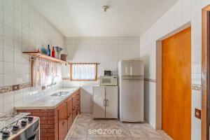 una cocina con frigorífico y fregadero en MCD - Casas en Campos do Jordão, en Campos do Jordão