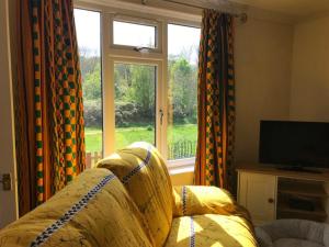 a living room with a couch and a window at River Airebnb in Bradford
