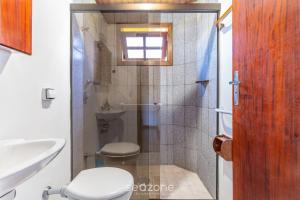 Un baño con ducha, inodoro y lavabo. en MCD - Casas en Campos do Jordão, en Campos do Jordão