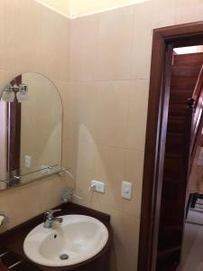La salle de bains est pourvue d'un lavabo et d'un miroir. dans l'établissement CASA DE CAMPO HOSPEDAJe, à Ambato