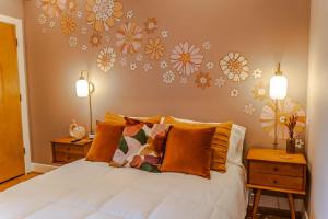 a bedroom with a bed with flowers on the wall at Groovy Condo in the Vibrant NuLu District in Louisville