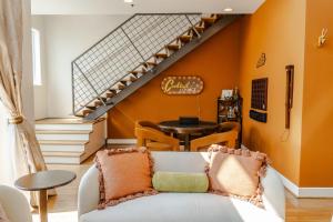 a living room with orange walls and a white couch at Groovy Condo in the Vibrant NuLu District in Louisville