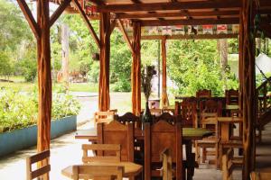 Hipilandia International Hostel في ليتيسيا: مجموعة طاولات وكراسي خشبية في الجناح