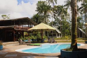 Hipilandia International Hostel في ليتيسيا: منتجع فيه مسبح وطاولة وكراسي