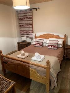 una camera da letto con un letto in legno e asciugamani di Chalet Serin a Saint-Jean-d'Aulps
