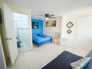 1 dormitorio con cama azul y baño en Esquina del Pintor en Guadalajara