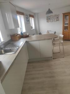 uma cozinha com armários brancos e um balcão de madeira em Beach Break Aberavon Holiday Home by the Sea em Port Talbot