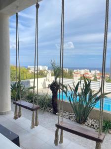 a swing on a balcony with a pool at Romeo & Juliet in Protaras