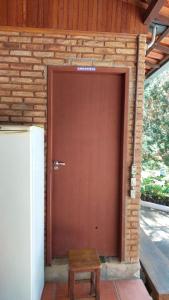 una puerta de garaje marrón con un banco delante en Recanto Saira, en Caeté