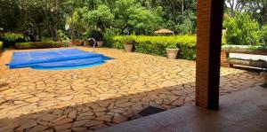 un patio de piedra con piscina en un patio en Recanto Saira, en Caeté