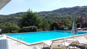 a swimming pool with chairs and an umbrella at Swimming and Sun in Gandosso