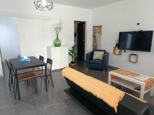 sala de estar con sofá y mesa en La casita de Aitor; campo y playa en el Médano, en El Médano