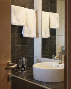 新卡利克拉蒂業的住宿－愛琴海藍色海灘酒店=，浴室设有水槽、两杯眼镜和毛巾