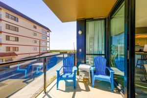 einen Balkon mit zwei blauen Stühlen und Blick auf ein Gebäude in der Unterkunft Sand & Sea: Beach Dreams (112) in Seaside