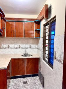 eine Küche mit einem Waschbecken und einem Fenster in der Unterkunft Vacations In in Nathia Gali