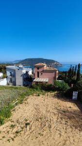 ein Haus auf einem Hügel mit dem Ozean im Hintergrund in der Unterkunft Serenity apartment-1st floor-Sea view- beach 200m away in Porto Rafti