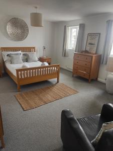 um quarto com uma cama, uma cómoda e um sofá em Beach Break Aberavon Holiday Home by the Sea em Port Talbot