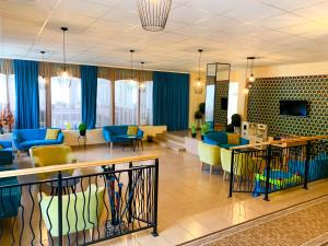 a lobby with a waiting room with blue and yellow chairs at Flóra Panzió in Miskolctapolca
